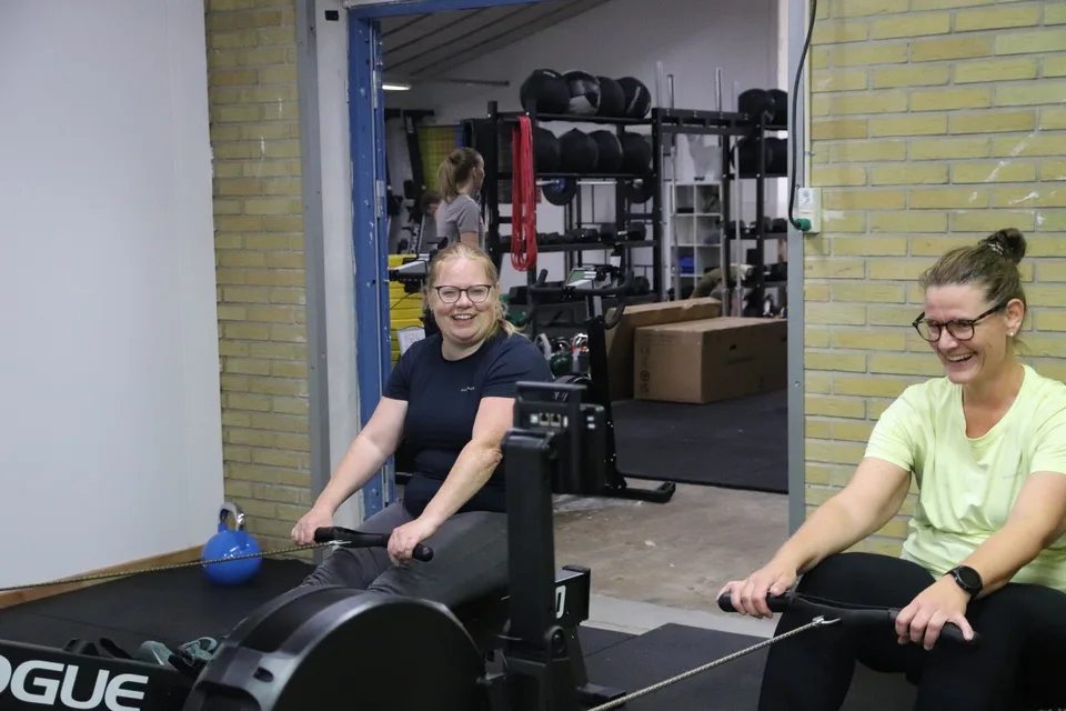 Box One Roskilde — to kvinder ler på roere