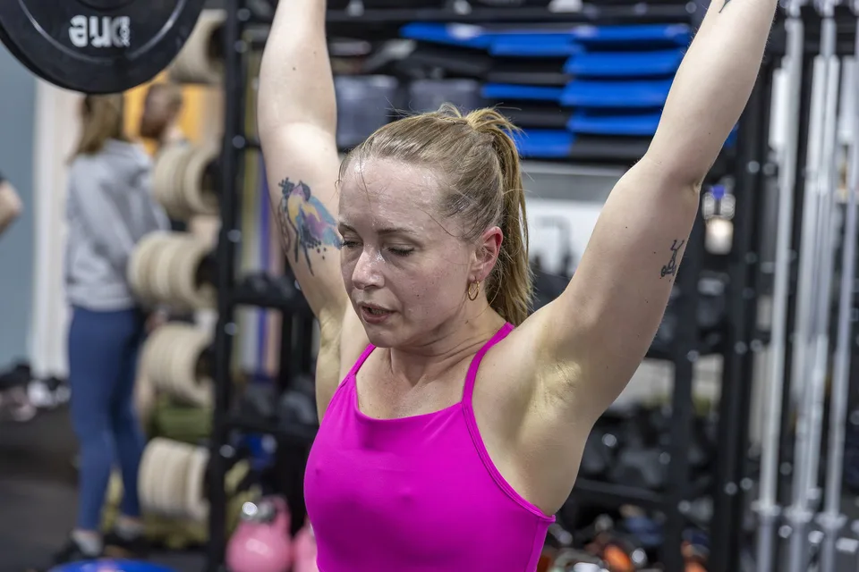 Box One Roskilde — kvinde i pink laver skulderpres, fokuseret