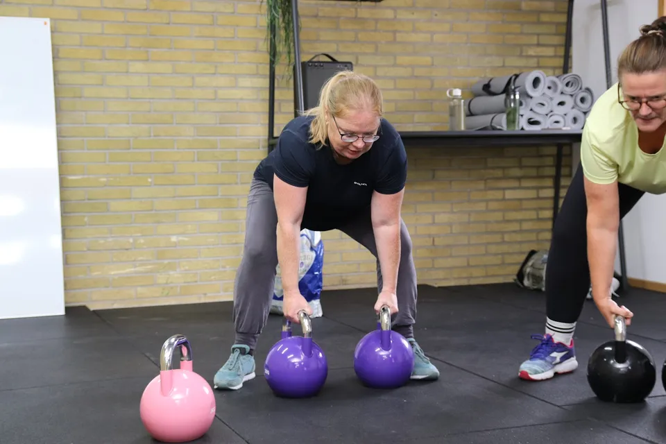 To kvinder træner med kettlebells i fitnesscenteret Box One i Roskilde