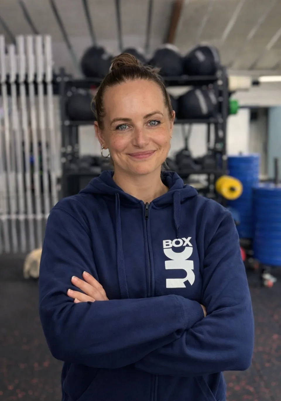 Ditte Holm, medejer og box manager hos Box One, fotograferet foran den samme grå baggrund som resten af holdet.