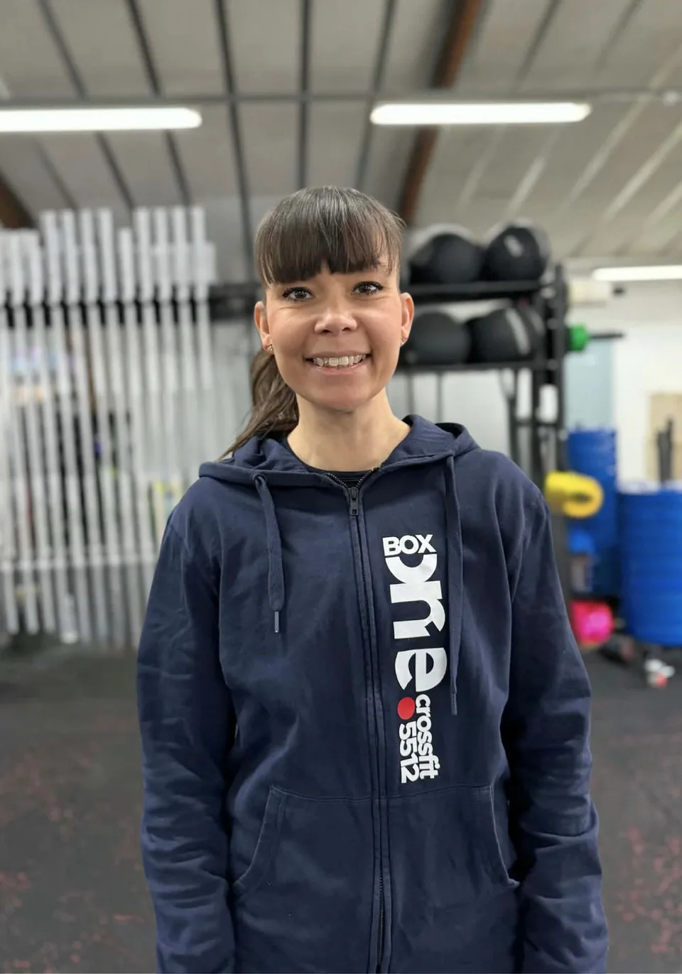 Gitte Foget, social media wizard hos Box One, fotograferet foran den samme grå baggrund som resten af holdet.