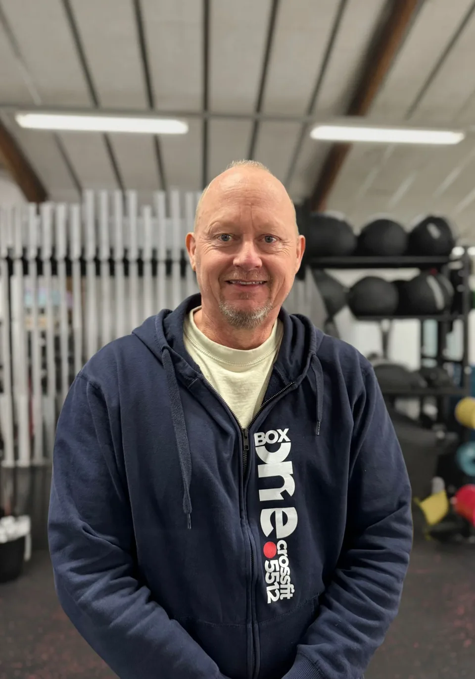 John Simonsen, holdunderviser hos Box One, fotograferet foran den samme grå baggrund som resten af holdet.