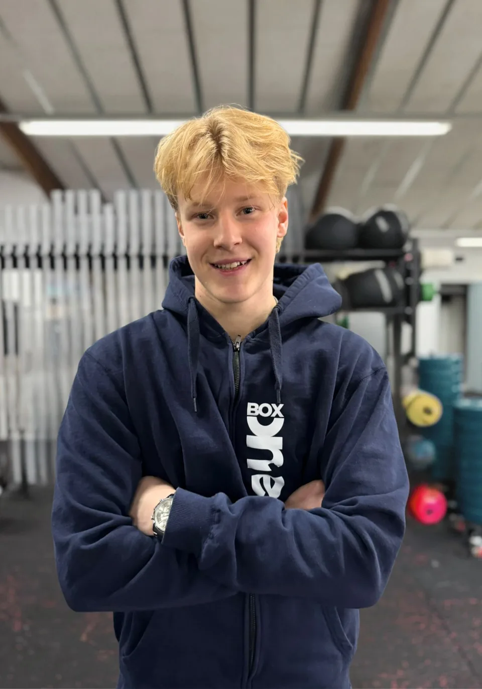 Marius, content creator hos Box One, fotograferet foran den samme grå baggrund som resten af holdet.