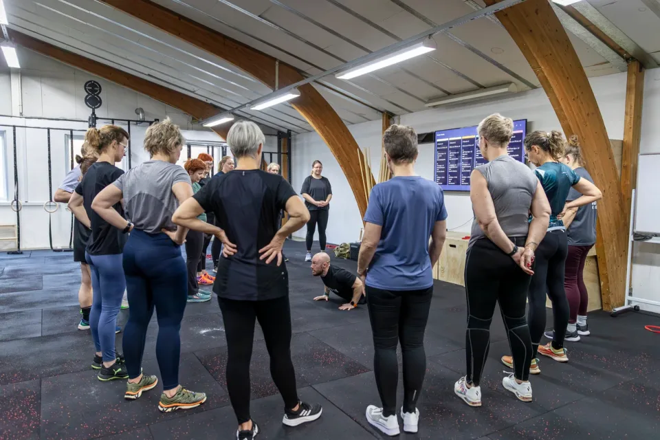 Et hold står i rundkreds omkring coachen under et introforløb i Box One.